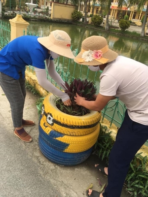Đoàn xã Hòa Bình chăm sóc bồn hoa trên lốp xe tái chế và trồng hoa khu vực sân vận động trung tâm xã.